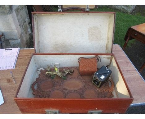 A leather suitcase, a carved wooden tray, a brass model of a dragon and a Kodak Brownie box camera