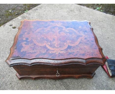 A 19th century lady's burr wood dressing box, of shaped rectangular form and having inlaid decoration, the velvet interior fi