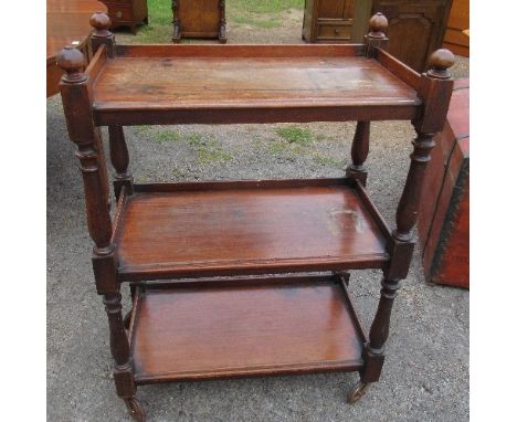 A 19th century mahogany three tier buffet, with turned supports, on wheels, 28ins x 16is x&nbsp; height 39ins