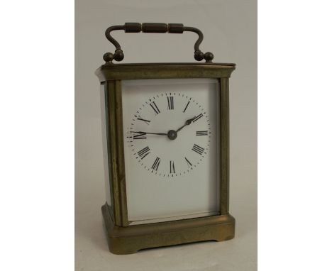 A gilt metal cased carriage clock, with white enamel dial and Roman numerals, height with handle 5.5ins