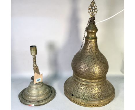 An early 20th century Middle Eastern candle stick on circular base (3)38cm high, a later similar hanging lantern with pierced