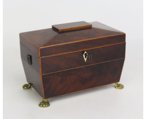A Georgian mahogany and boxwood strung tea caddy of sarcophagus outline, the shallow domed hinged lid enclosing two lidded co