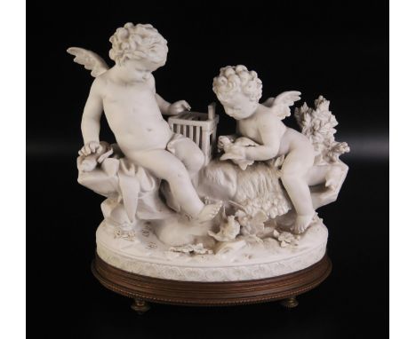 A continental bisque porcelain figure group of cherubs with birdcage and birds, on a naturalistic base, mounted on a gilt met