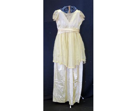 A 1920's pale apricot silk coming out dress, with applied lace to the V-neck and shoulder straps, with net overskirt fixed wi