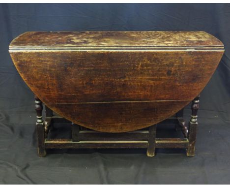 A late 18th century oak drop flap table, with hinged D-shaped flaps on a gate leg action, with turned under framing, 140cm ex