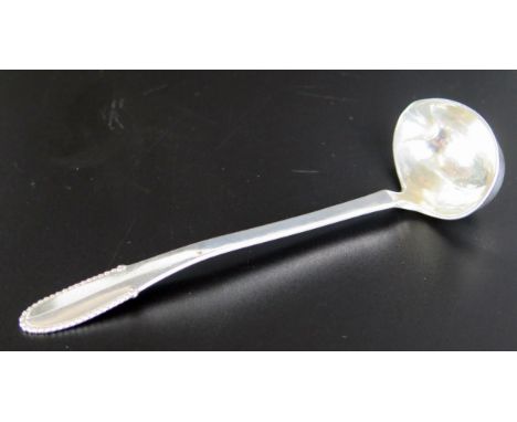 A Georg Jensen beaded pattern cream ladle, stamped marks and import marks, 13cm long, 23gms, 0.75ozs 
