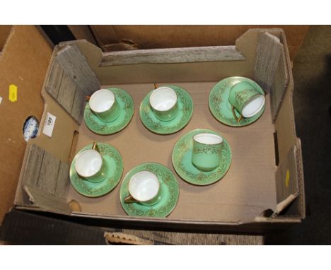 A SET OF SIX GREEN AND GILT ROYAL DOULTON COFFEE CUPS AND SAUCERS 