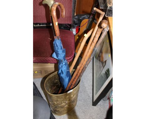 A BRASS STICK STAND CONTAINING VINTAGE WALKING STICKS, ETC.