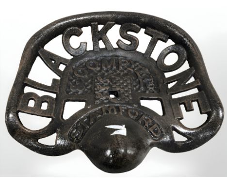 A reproduction black stone cast tractor seat.