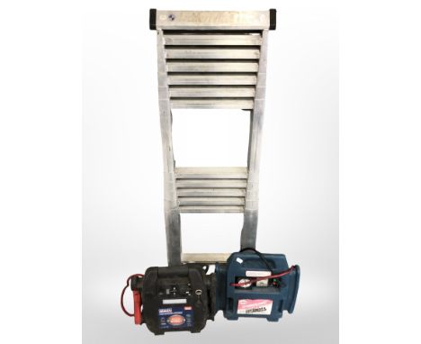A telescopic ladder, together with two battery jumpstarters.