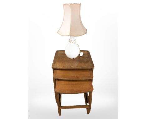 A nest of Nathan teak occasional tables, width 53 cm, together with a table lamp.