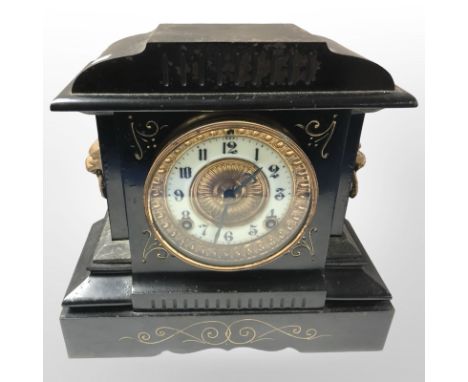 A late Victorian cast iron eight day mantel clock with enameled dial, height 27 cm.