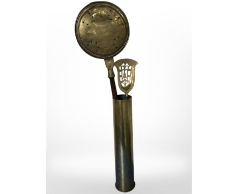 A large brass ammunition shell containing a brass bed warming pan and coal shovel 