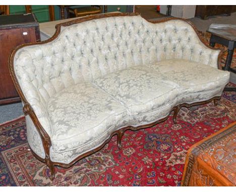 A George III style mahogany framed sofa, late 19th century, recovered in green buttoned fabric, with moulded and carved frame