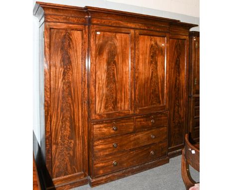 A 19th century mahogany triple wardrobe, 245cm by 65cm by 214cm.  A few superficial scrapes to the main body, cracks to the r