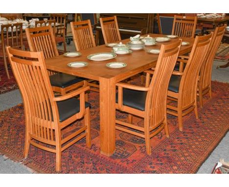 A modern oak plank-top dining table, with square supports, together with a set of eight matching stick back carver arm chairs