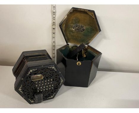 A Victorian concertina, by Lachenal &amp; Co, London with foliate pierced and inlaid ebonised ends with original box (box nee