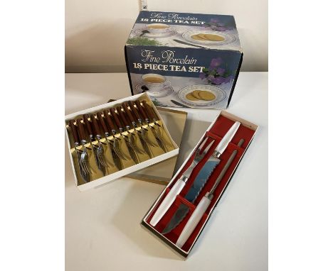 A 18 piece boxed porcelain tea set with two boxes of cutlery, shipping unavailable