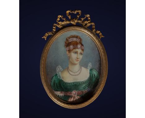 This miniature framed in a golden oval represents a lady adorned with a tiara and an emerald green dress. The use of ivory as