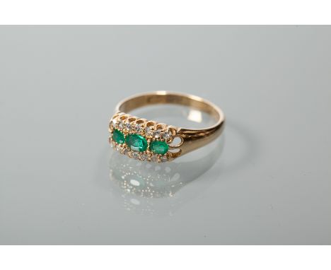 EMERALD AND DIAMOND CLUSTER RING
horizontally set with three oval cut emeralds, flanked by two rows of rose cut diamonds, in 