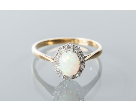 EARLY TWENTIETH CENTURY OPAL AND DIAMOND CLUSTER RING
with a central oval cabochon opal, surrounded by brilliant cut diamonds