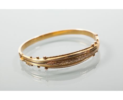 VICTORIAN NINE CARAT GOLD BANGLE
engraved with a scrolling decoration, and with beaded edging, hallmarked, 8.2g