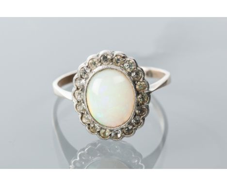 OPAL AND PASTE CLUSTER RING
with a central oval cabochon opal, surrounded by colourless pastes, unmarked, size R-S