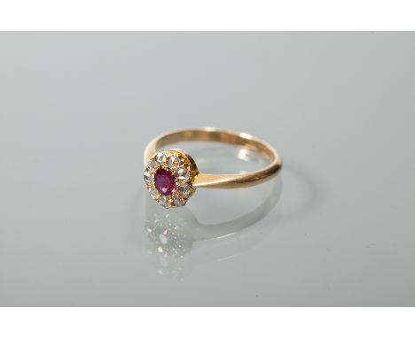 RUBY AND DIAMOND CLUSTER RING
with a central oval ruby surrounded by rose cut diamonds, marked 18ct for eighteen carat gold, 