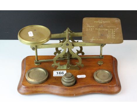 Late 19th / Early 20th century Set of Brass Postal Scales with Six Weights, on wooden base,  20cms long 