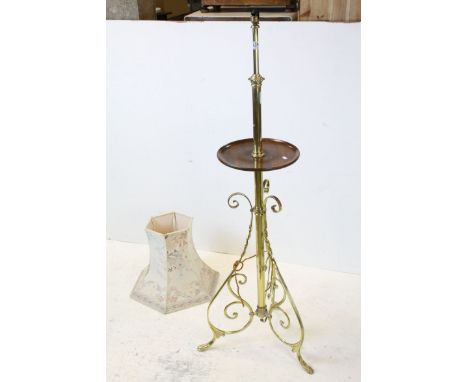 1930's Brass Standard Lamp with wooden wine shelf and raised on three scrolling supports, 135cms high, with shade 