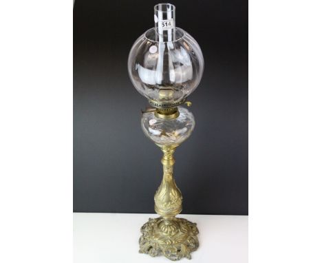 An antique brass French oil lamp of classical form with clear glass well shade and chimney. 