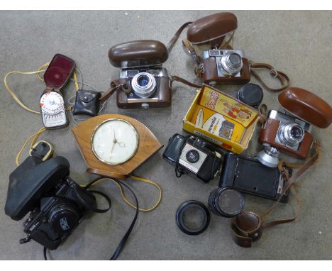 A collection of vintage cameras and accessories: Voigtlander, Brownie, lens, light meter and a clock 