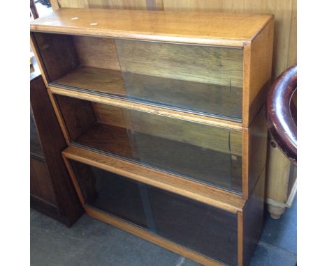 A LIGHT OAK THREE PART SECTION BOOKCASE WITH SLIDING GLASS DOORS W91CM D27CM H106CM