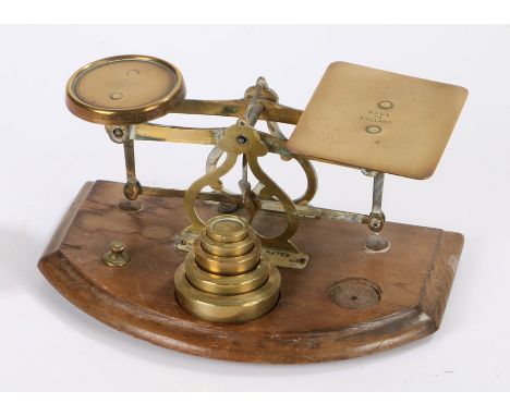 Set of brass postal scales, raised on shaped mahogany base, 19cm wide