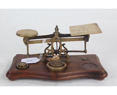 19th Century set of brass postal scales, one platform with postal rates, with wooden base and part weights, 24cm wide
