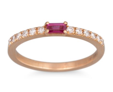 A RUBY AND DIAMOND RING, the baguette cut ruby to a diamond set band. in 18ct yellow gold. Size: M - N