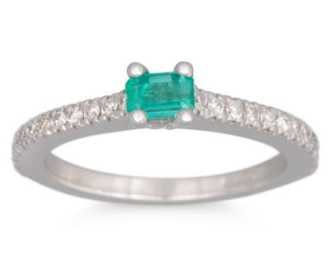 AN EMERALD AND DIAMOND RING, the rectangular emerald to a diamod set band, in 18ct white gold. Estimated: weight of emerald: 