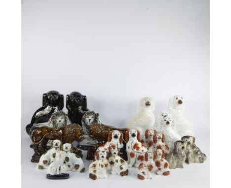 A varied collection of Staffordshire pottery figurines, mainly consisting of Staffordshire spaniels and 2 pairs of lion figur