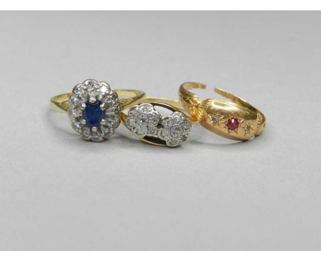 A collection of three rings, comprising; an oval sapphire and diamond cluster ring, not stamped, a diamond set double floral 