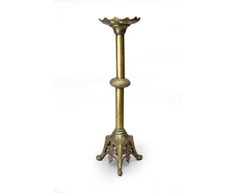 A large brass ecclesiastical style candlestick, circa 1900, with floret drip pan above a knopped stem and raised on a foliate