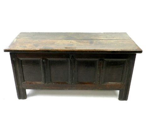 A 17th century oak coffer, the twin plank top above a quadruple panelled front, the stiles unusually carved with long nulls, 