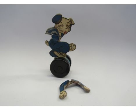 A Chad Valley pull along dog, the printed card dog in a sailors outfit, on wooden stand with Bakelite wheels (a/f) 