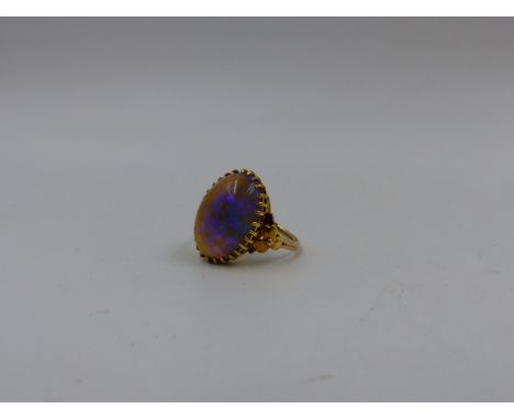 AN EARLY PRECIOUS YELLOW METAL NATURAL OPAL CABOCHON RING. OPAL SIZE APPROXIMATELY 1.8cm x 1.2cms.