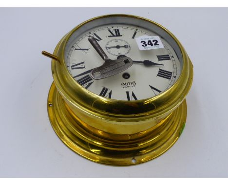A BRASS CASED SMITHS BULKHEAD TYPE CLOCK WITH PAINTED ROMAN NUMERAL DIAL.