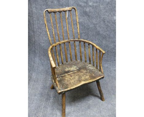 AN ANTIQUE COUNTRY MADE RUSTIC WINDSOR ARMCHAIR WITH UNUSUAL COMB BACK AND SHAPED SEAT.