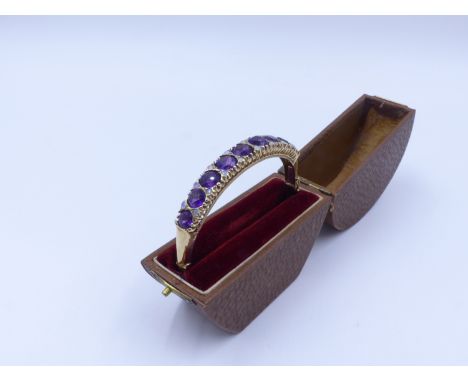 A 9ct. AMETHYST AND OPAL HINGED BANGLE WITH FIGURE OF EIGHT SAFETY CHAIN. HALLMARKED LONDON, DATED 1993.  THE NINE ROUND BRIL