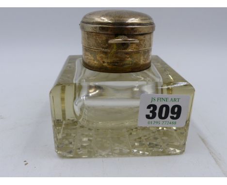 A SILVER MOUNTED GLASS SQUARE SHAPED DESK INKWELL, THE TOP INCORPORATING A SILVER POCKET WATCH.  BIRMINGHAM 1905.   8.5cms.
