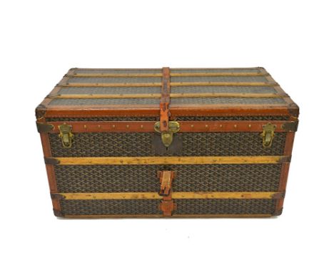 An E. Goyard Aine monogram trunk, leather bound and with wooden battens, brass side carrying handles, two lift out interior t