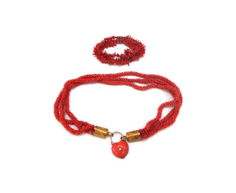 A Victorian three strand coral bead necklace, with engraved gold terminals, cabochon coral and seed pearl heart shaped clasp 