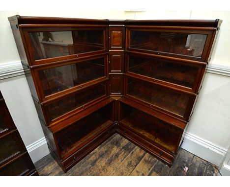 A Globe Wernicke mahogany four tier corner bookcase, with glazed up and over doors, drawers below, three cupboards to the cor